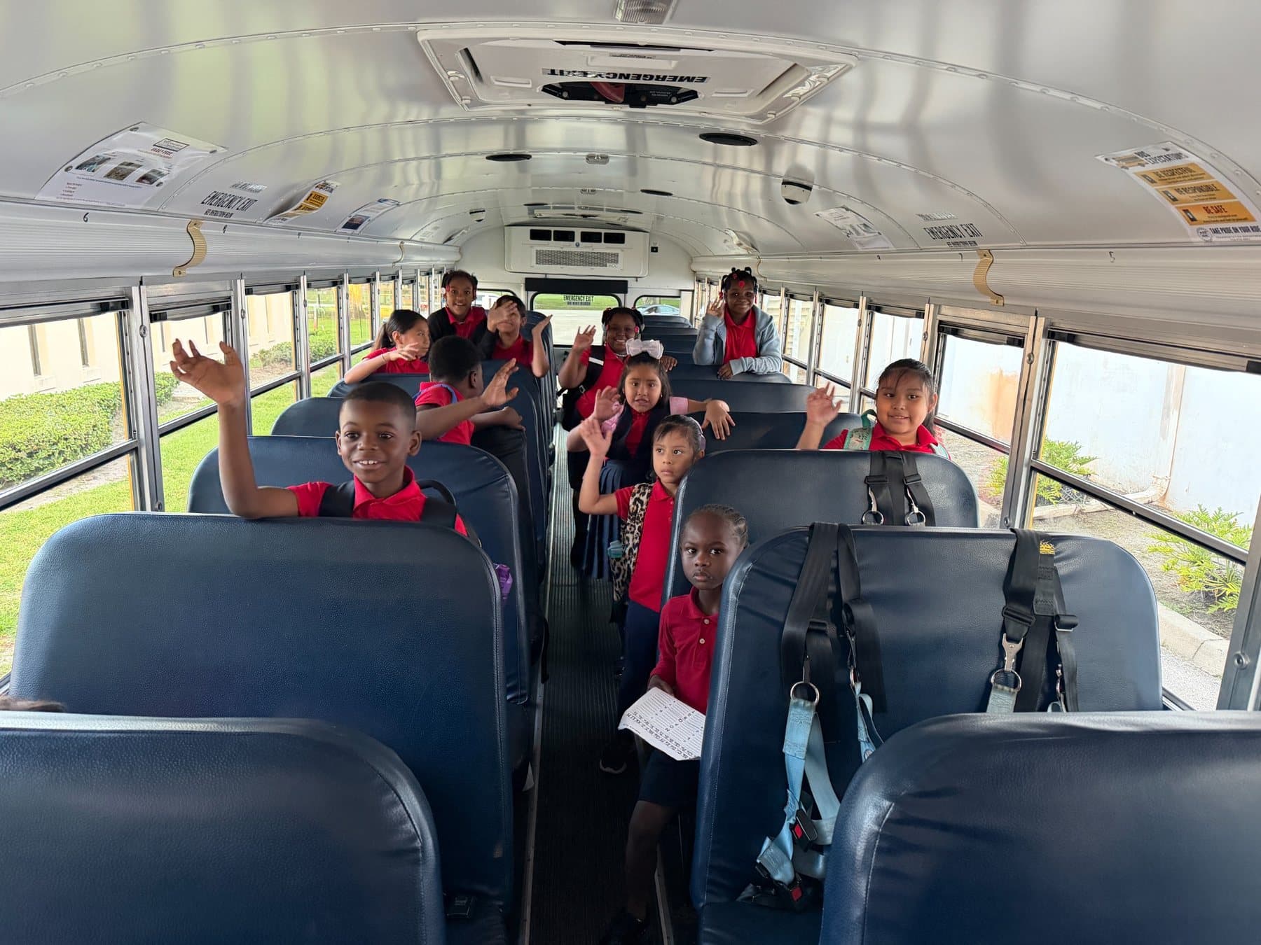 A Saint Peter’s Academy student smiling and waving during the school day.