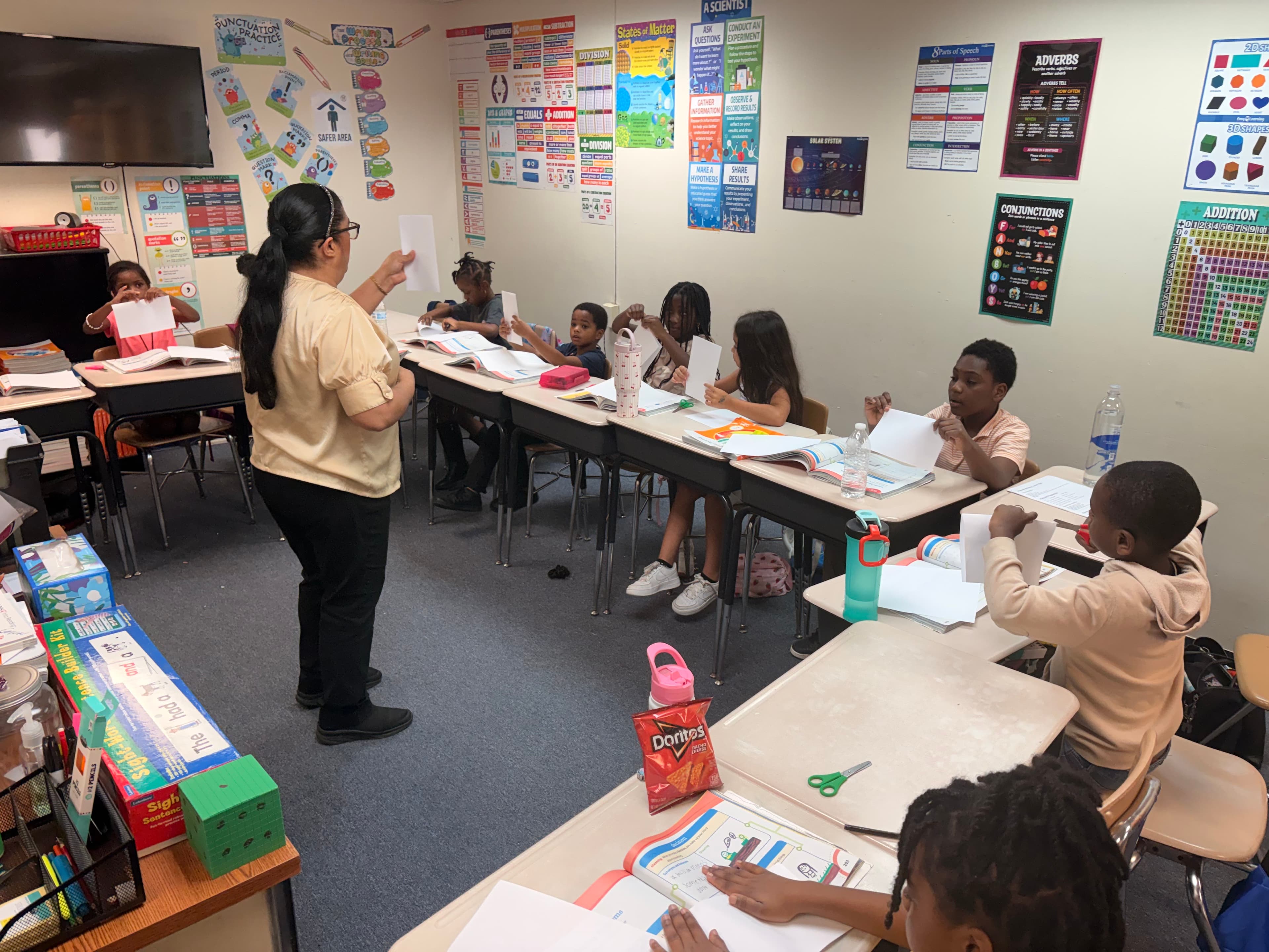 A teacher and students creating books in a Saint Peter’s Academy classroom.